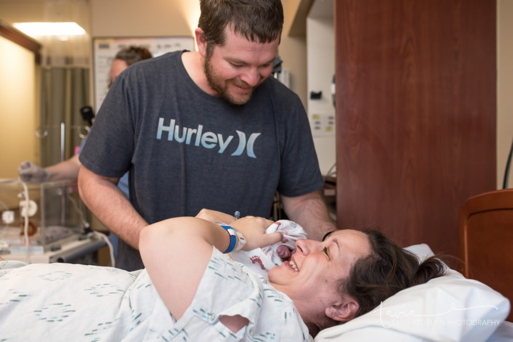 oklahoma birth photographer mom and dad lock eyes the first time holding their baby
