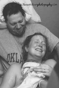 mom holding new baby delivered at home with dad