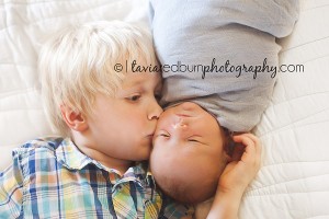 adorable big brother kissing baby brother on the cheek