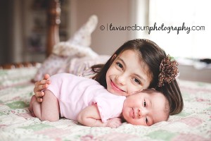 newborn baby girl with big sister during lifestyle newborn session
