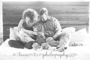 parents snuggling with their kid and baby girl newborn