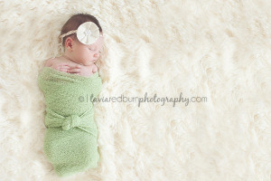 sleeping baby girl wrapped in a green wrap