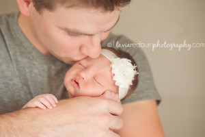 dad kissing little newborn baby girl