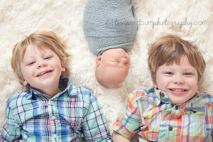 newborn baby with his siblings, older brothers pose laughing