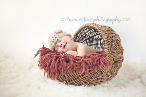 newborn baby boy smiling in basket