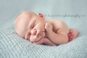newborn boy with hands on face pose