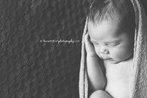 black and white newborn pose, hand by face, wrapped