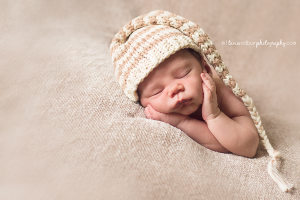 sweet newborn pose with neutral long hat