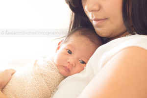 awake newborn snuggled on mama